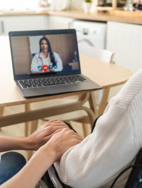 Asian senior male and daughter video call with doctor in living room. Elderly old mature grandfather sitting on table with young granddaughter, using computer laptop consult with general practitioner.